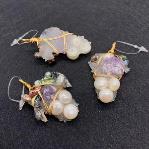 Detail view of handmade amethyst and pearl grape pendant with gold wire wrapping