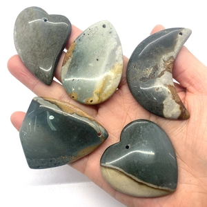 Hand holding natural grey green agate pendants in heart, moon and water drop shapes