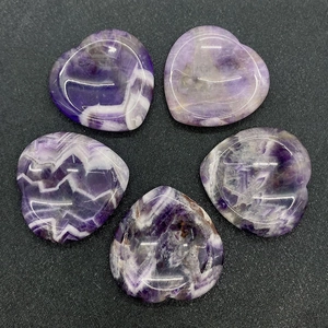 Vista dettagliata di pietre di ametista lucida a forma di cuore con striature viola e bianche