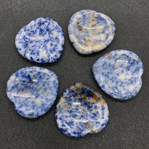 Macro view showing five heart-shaped blue sodalite stones with polished natural texture