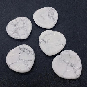 Vue à plat de pierres de howlite blanche en forme de cœur avec veines grises au fond