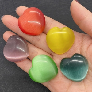 Perline a forma di cuore in pietra occhio di gatto colori misti sulla mano