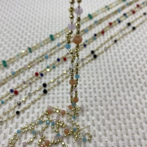 Close-up of faceted colorful stone bead chains with gold metal balls for DIY jewelry