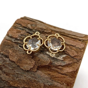 Detailed view of flower-shaped natural crystal pendants with gold milgrain trim