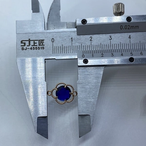 Macro detail of a 14mm faceted blue stone pendant with gold flower connector and calipers