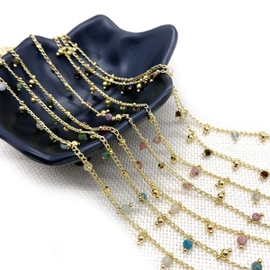 Golden chain jewelry with colorful natural stone beads on black leaf tray