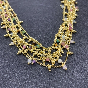 Multilayer bohemian necklace featuring colorful faceted beads and golden chain layers