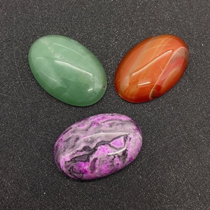 Detailed top view of oval natural red agate, green aventurine, and purple gemstone cabochons