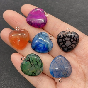 Detailed view of colorful heart-shaped striped agate pendants with silver metal rings
