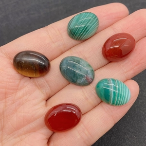 Close-up of six mixed 13x18mm oval gemstone cabochons held in hand for scale