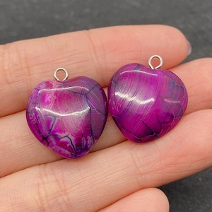 Macro view of purple heart-shaped agate pendants with black spiderweb vein textures