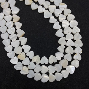 Detalle de cuentas de nácar natural en forma de corazón con brillo irisado para joyas