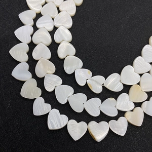 Vista macro detallada de cuentas de nácar blanco natural en forma de corazón para joyería