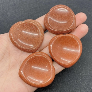 Close-up of heart-shaped goldstone thumb stones with smooth polished surface