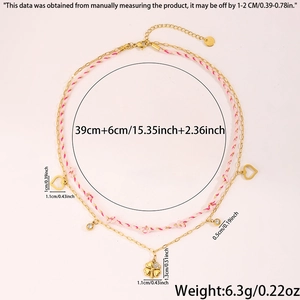 Détail d'un collier à double épaisseur en corde rose avec trèfle et cœurs