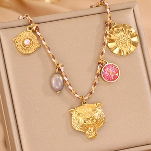 Collier en corde tissée main avec tête de tigre dorée et pendentifs soleil sur boîte à bijoux