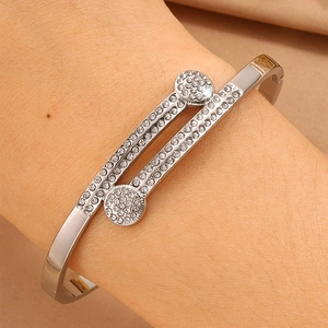 Detail of silver-tone titanium steel cuff bracelet featuring dual discs with pavé crystals