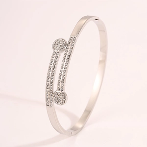 Macro shot of silver bangle featuring double-headed circular ends with crystal pavé setting