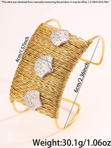 Macro shot of gold woven cuff bracelet with silver shells and rhinestones detail