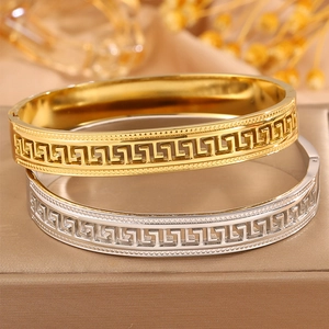 Matching gold and silver stainless steel bangles with intricate Greek key pattern design