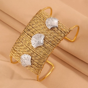 Detailed close-up of woven gold wire bangle with crystal-encrusted silver shells
