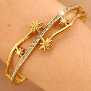 Bracelet ondulé plaqué or avec strass étincelants et breloques étoiles sur le poignet