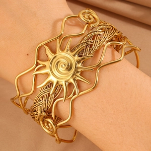 Detail of bohemian gold sun totem cuff bracelet with woven texture and open design