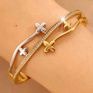 Bracelet vague bicolore doré orné de trèfles à quatre feuilles sertis de diamants fins