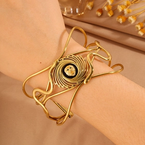Detail of a vintage golden cuff bracelet featuring a central lion head and snake motifs