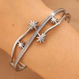 Détail du bracelet rigide argenté à cadre ondulé avec motifs étoiles et zircons brillants