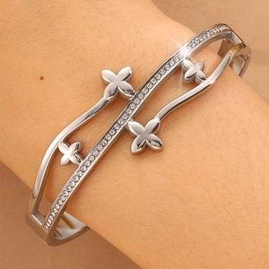 Détail macro du bracelet trèfle argenté avec pavage de pierres étincelantes