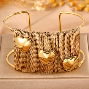 Ethnic style woven titanium steel open bangle with triple gold heart accents on a jewelry box