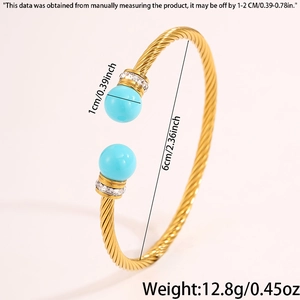 Détail d'un bracelet jonc torsadé doré avec des perles bleues et des cristaux