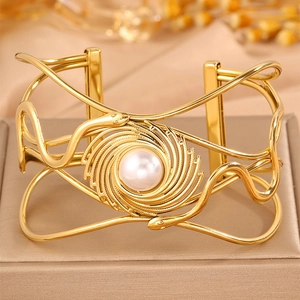 Ethnic style woven snake-shaped open bangle with central white pearl in golden finish