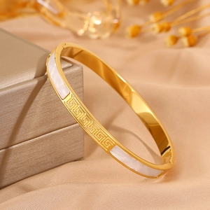 Golden stainless steel bangle featuring Greek meander pattern and white shell inlay