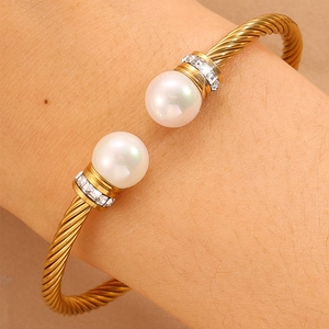 Détail du bracelet en fil d'or torsadé avec deux perles et accents de strass