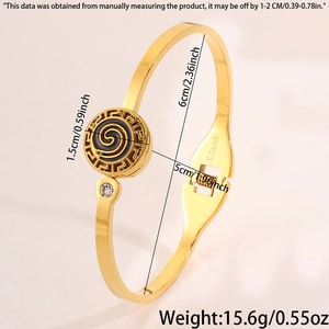 Detail of gold stainless steel bangle with black spiral pattern and inset white zircon