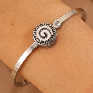 Detailed shot of silver Greek meander bangle with swirl pattern and small crystal