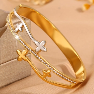 Détail du bracelet trèfle bicolore avec incrustations de cristaux sur fond satiné