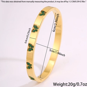 Detailoverzicht van de gouden titaniumstalen armband met vijf smaragdgroene vlinders