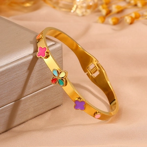 Détail du bracelet trèfle doré avec fleurs en émail coloré sur boîte à bijoux
