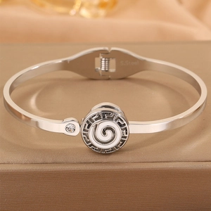 Macro detail of stainless steel cuff bracelet with Greek meander design and zircon stone