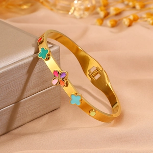 Détail des trèfles en émail coloré sur un bracelet doré avec un fermoir à ressort