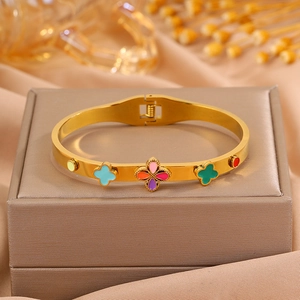 Gros plan d'un bracelet en acier doré avec des motifs de trèfles en émail coloré