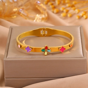 Détail d'un bracelet doré avec des trèfles en émail coloré et un fermoir à ressort pratique