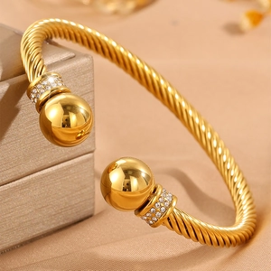 Détail du bracelet doré torsadé avec des sphères serties de strass étincelants
