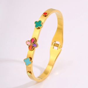 Détail du bracelet en acier titane doré avec breloques en émail et fermoir à charnière
