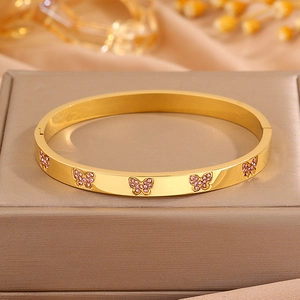 Detail van een gouden titanium stalen armband met roze kristallen vlinderpavé-zetting