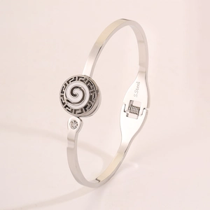 Detail shot of the polished stainless steel cuff bracelet with Greek Key pattern and diamond