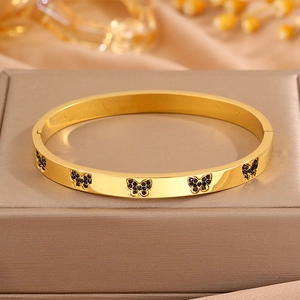 Detailopname van gouden vlinderarmband met zwarte details op een luxe sieradendisplay